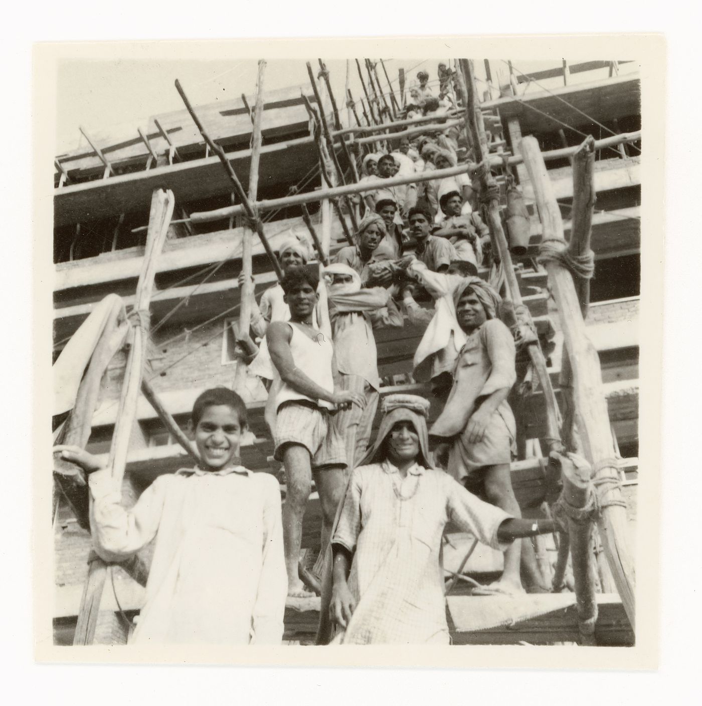 Portrait of construction workers passing on material supplies to upper levels of building, Chandigarh, India
