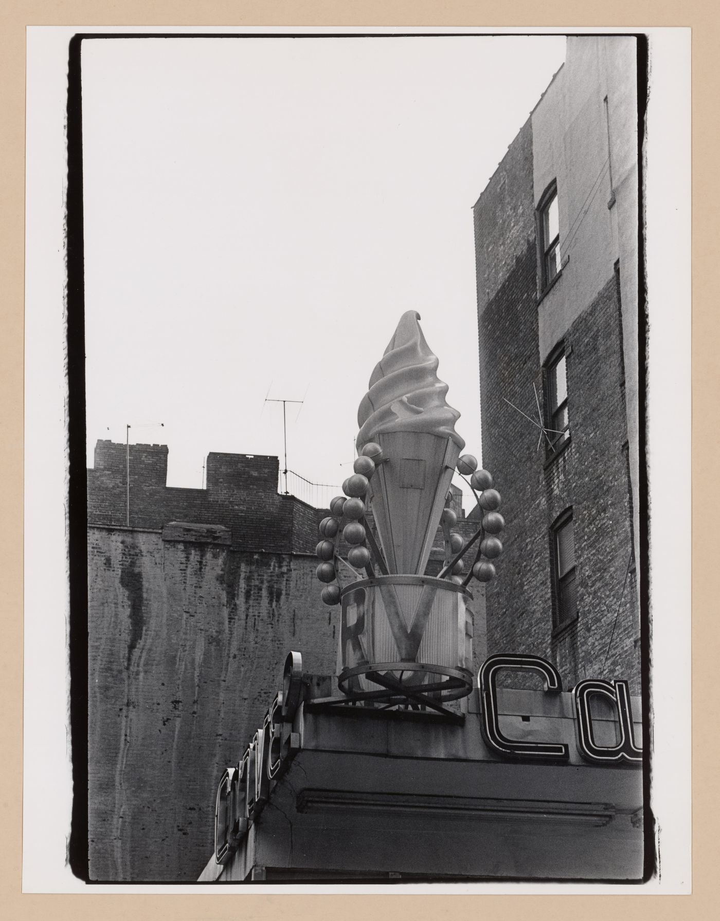 Partial view of a roof top showing signs with an artificial ice cream cone, New York City, New York