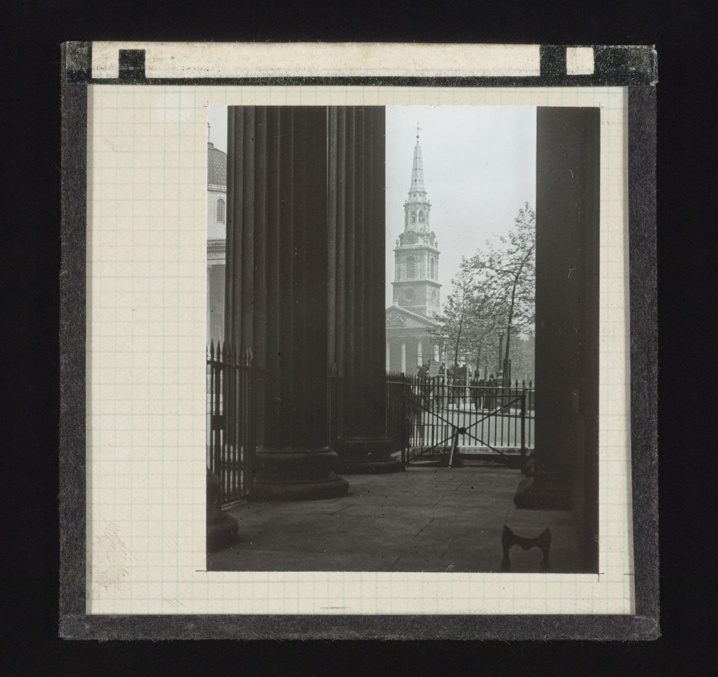 Distant view of the St Martin-in-the-Fields church through the columns of the headquarters of the Royal College of Physicians (now the Canada House) on Trafalgar Square, London, United Kingdom