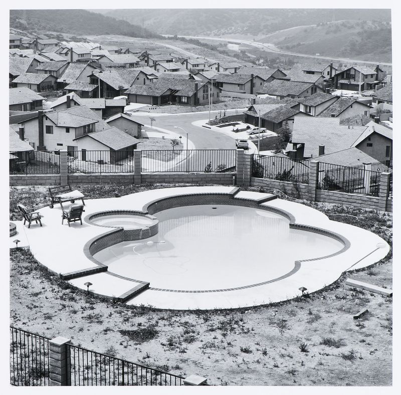 Joe Deal, photographe. Cour arrière clôturée et piscine, avec un ensemble résidentiel en contrebas, Diamond Bar, Californie. 1980