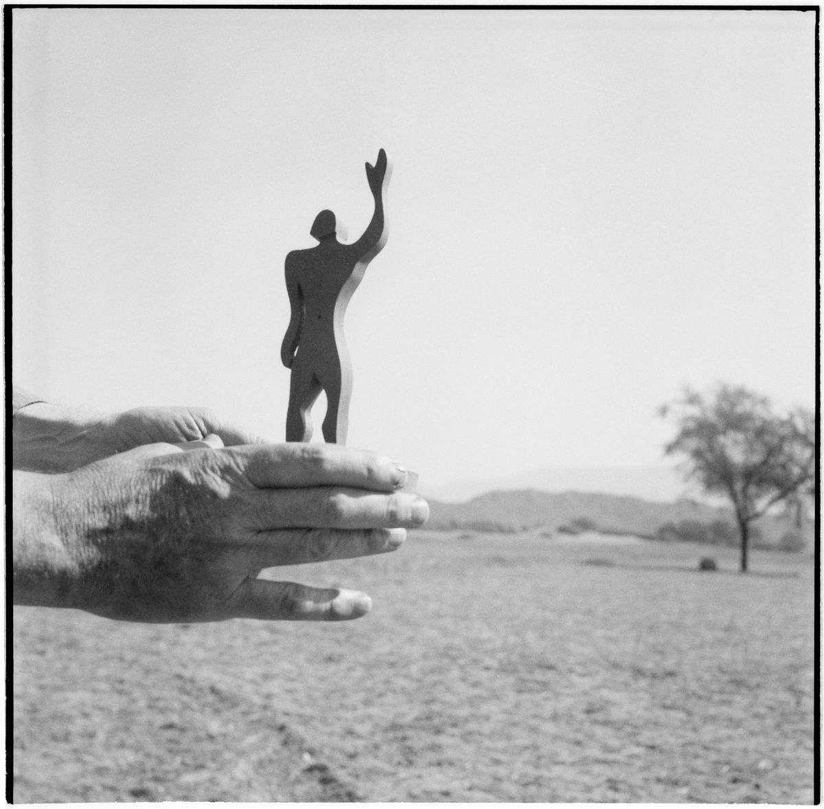 Le Corbusier's hand holding the silhouette of the Modulor while sighting the Chandigarh plain and the Siwalik mountain range